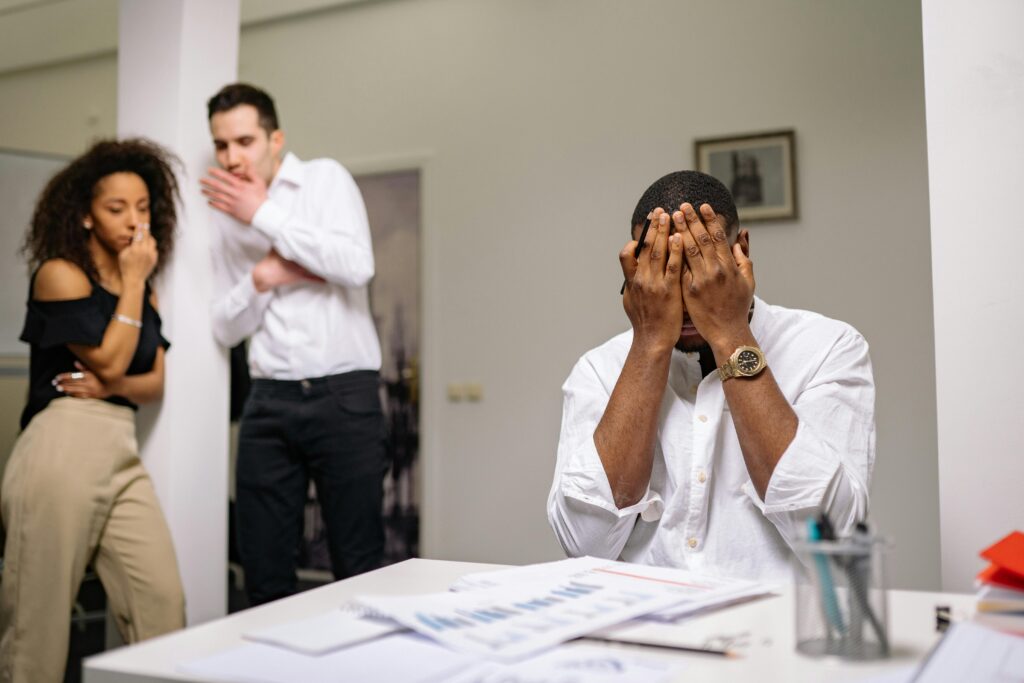 Diverse coworkers in tense office conflict scene, highlighting workplace issues.